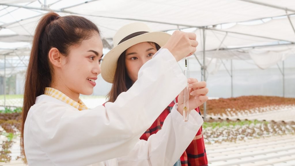 Asian scientist woman check chemical inspection soil PH tester in organic farm.