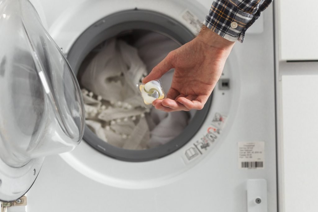 Gel caps in hand for washing machine, liquid coloured detergent and conditioner